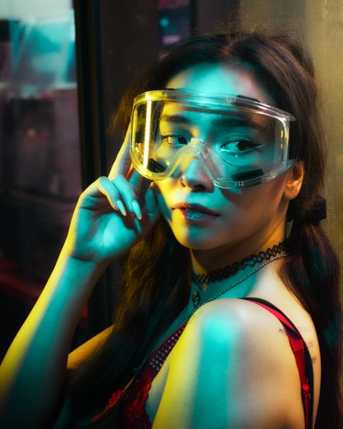 Free A vibrant portrait of a woman wearing protective goggles, exuding a modern and fashionable vibe. Stock Photo