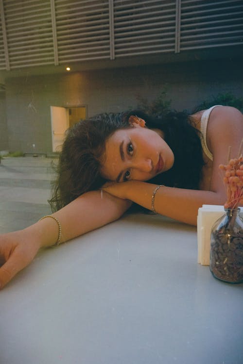 Free Young Woman Resting Her Head on the Table  Stock Photo