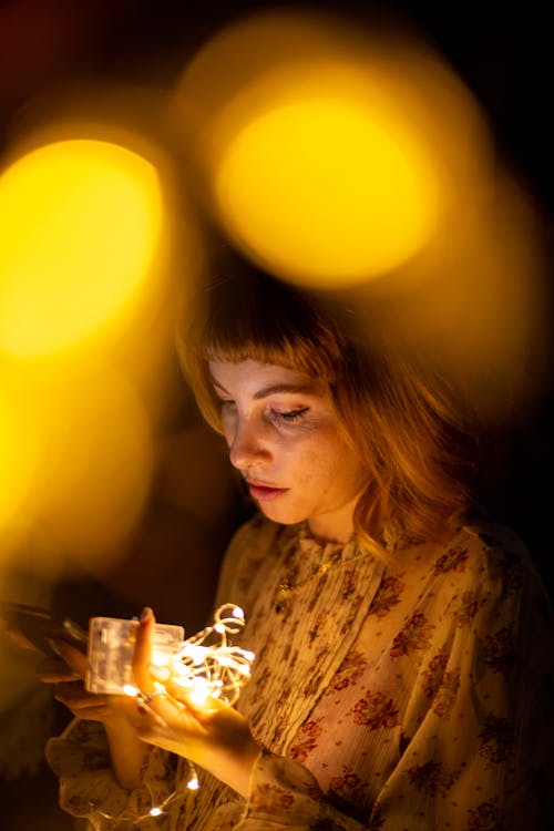 Photographie De Mise Au Point Sélective De Femme Tenant Des Guirlandes Lumineuses