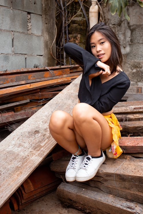 Woman Sitting Beside Wood Planks