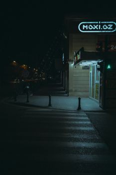 Moody night street scene with Maxi.az store in Baku, Azerbaijan, featuring urban crosswalk.