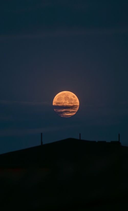 Free Dramatic full moon rising over a dark silhouette of a hill in Merzifon, Amasya, Türkiye. Stock Photo