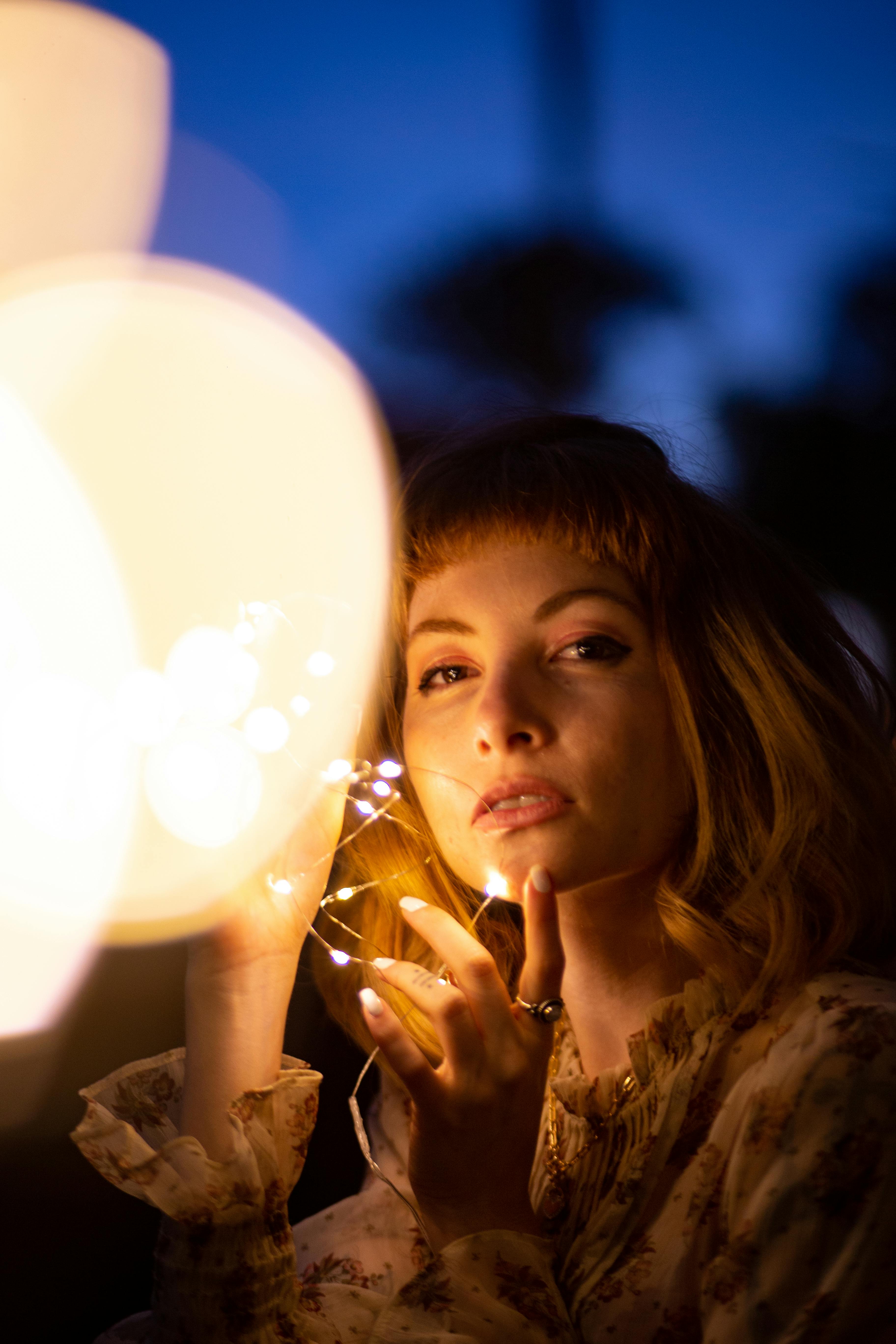 在喜怒无常的气氛中，串灯轻轻照亮了一个女人的迷人形象