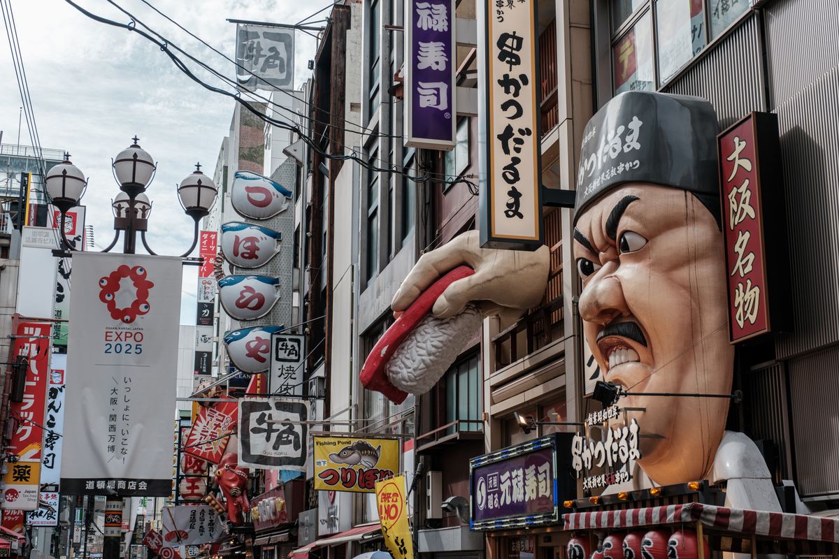 Dynamic Dotonbori street view in Osaka with bustling urban life and iconic signs
