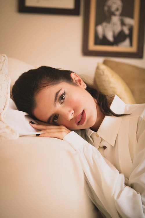 Femme Appuyée Sur Un Canapé Blanc à L'intérieur De La Chambre