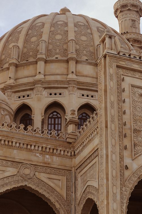 Free Detailed view of Mughal architectural designs with intricate carvings on a dome. Stock Photo