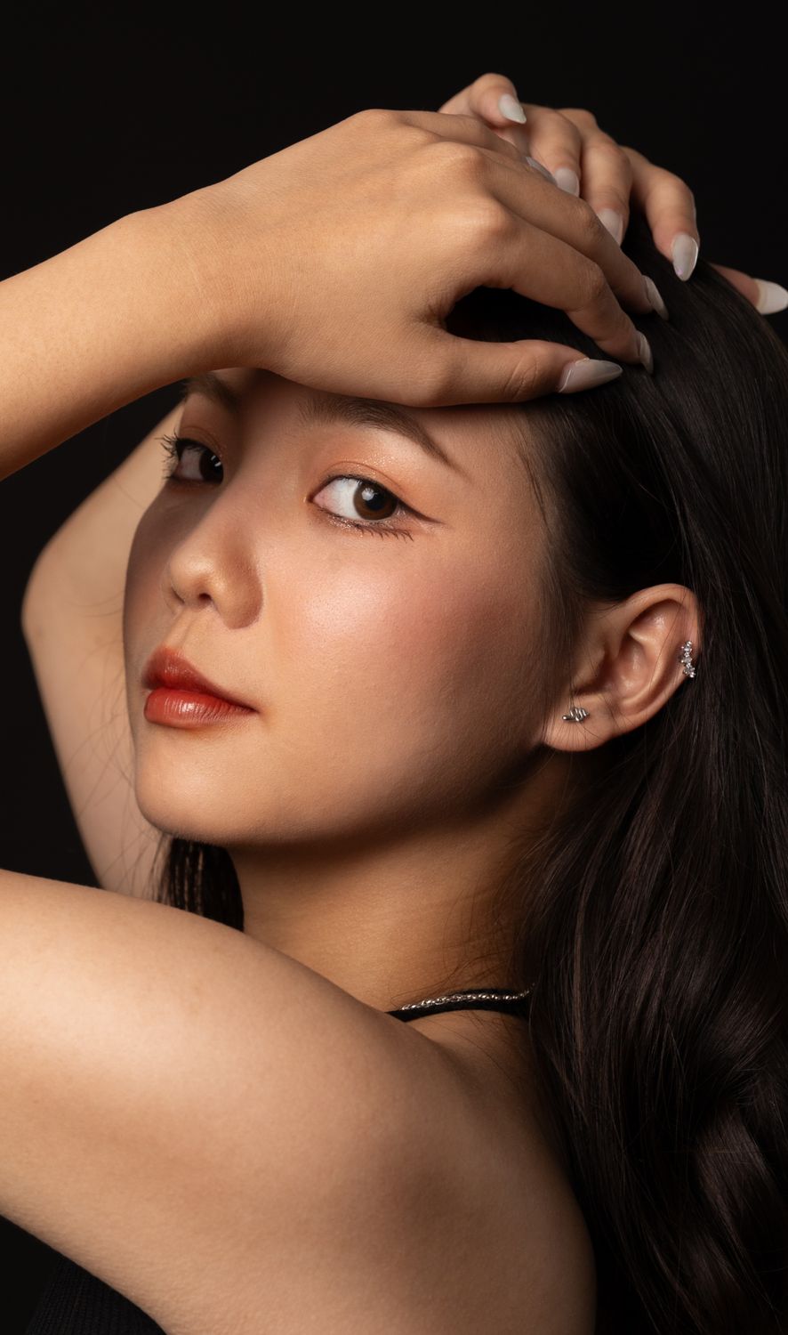 Studio Shot of a Young Woman Holding Her Hands on Her Head · Free Stock ...
