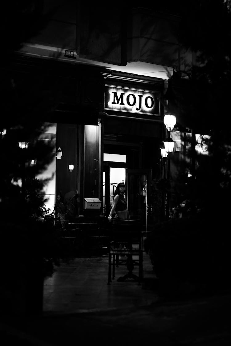 Woman Standing In Front Of A Restaurant At Night