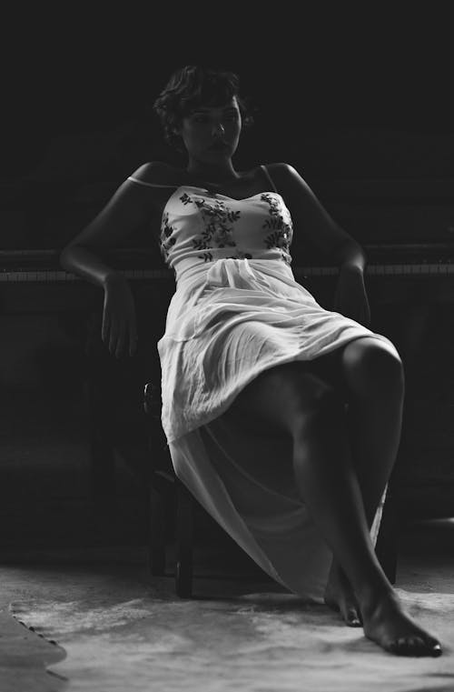 Grayscale Photo of Woman Sitting on Chair