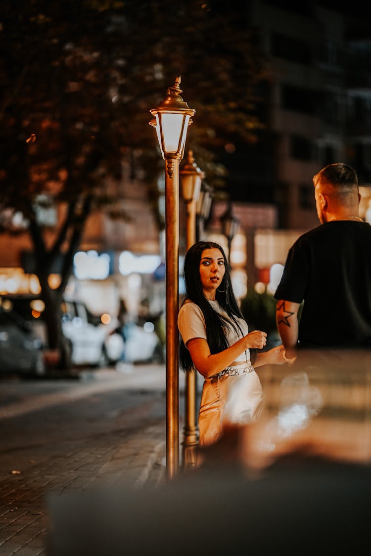 Man And Woman Standing On The Street At Night