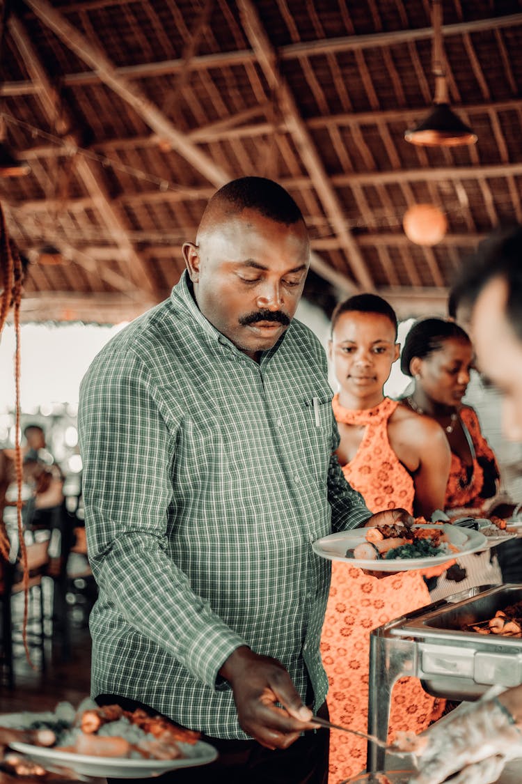 People Standing In Line For Food At A Celebration 