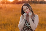 日落时分，一名戴眼镜、有纹身的女子穿着豹纹连衣裙摆着姿势