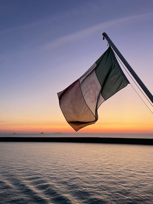 Mexican Flag over Sea at Dusk