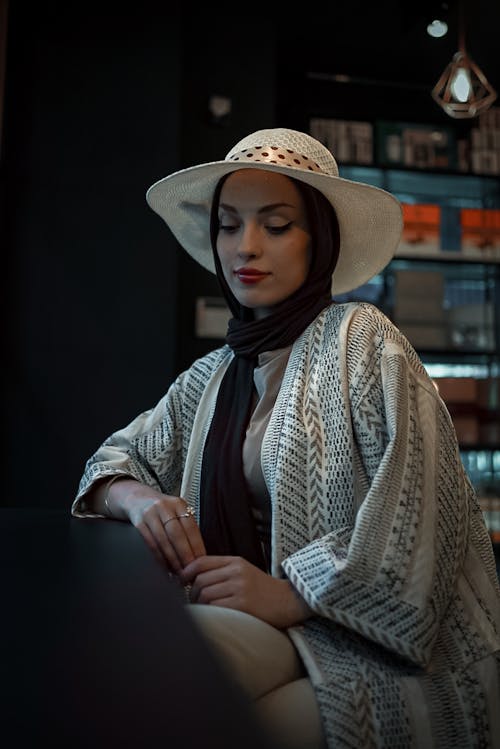 Woman Sitting in Hat and Hijab