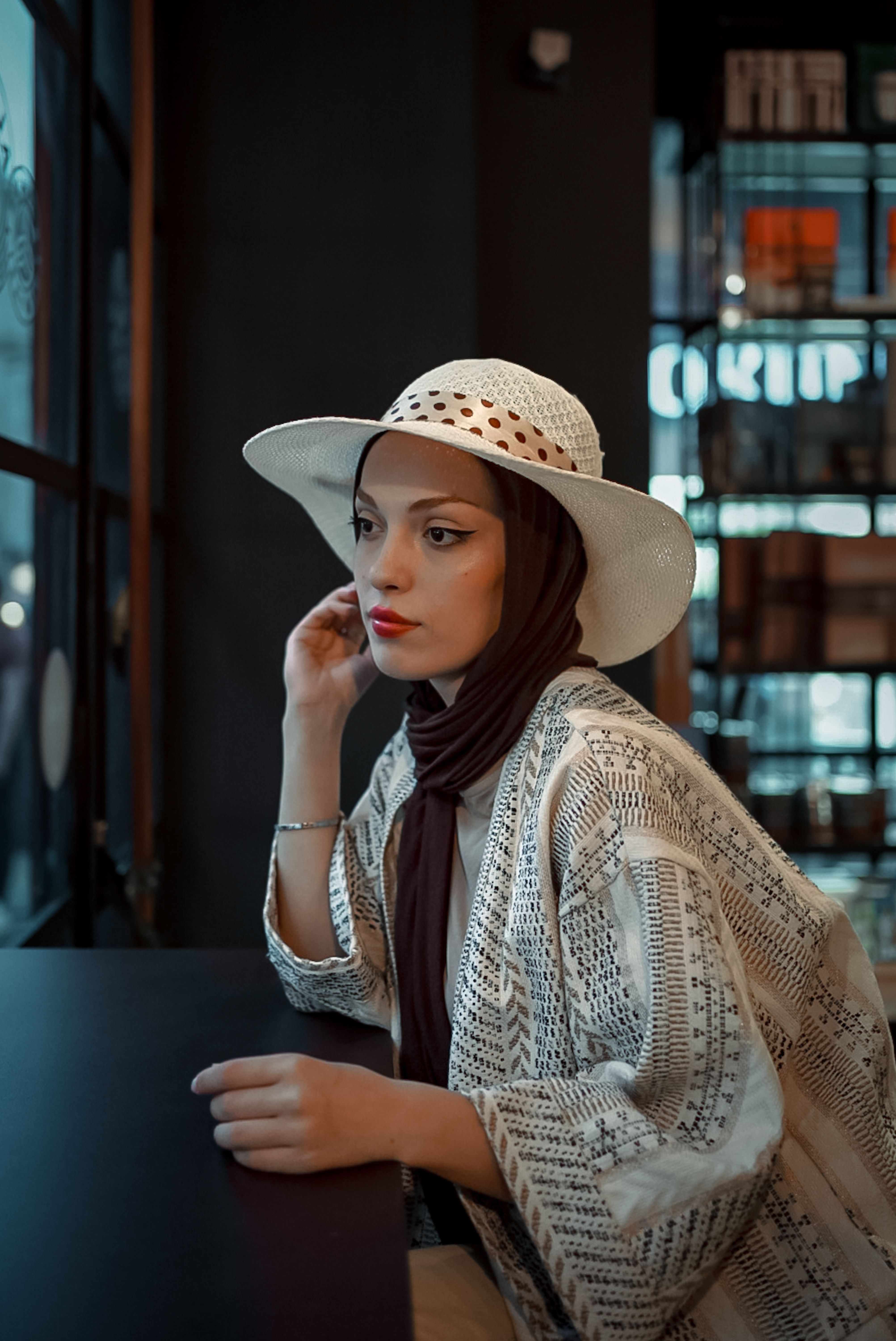 Woman in Hat and Hijab Sitting by Table · Free Stock Photo