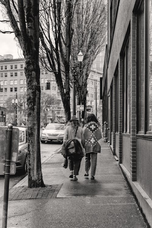 Black and White Photo of a Couple Walking on a Street