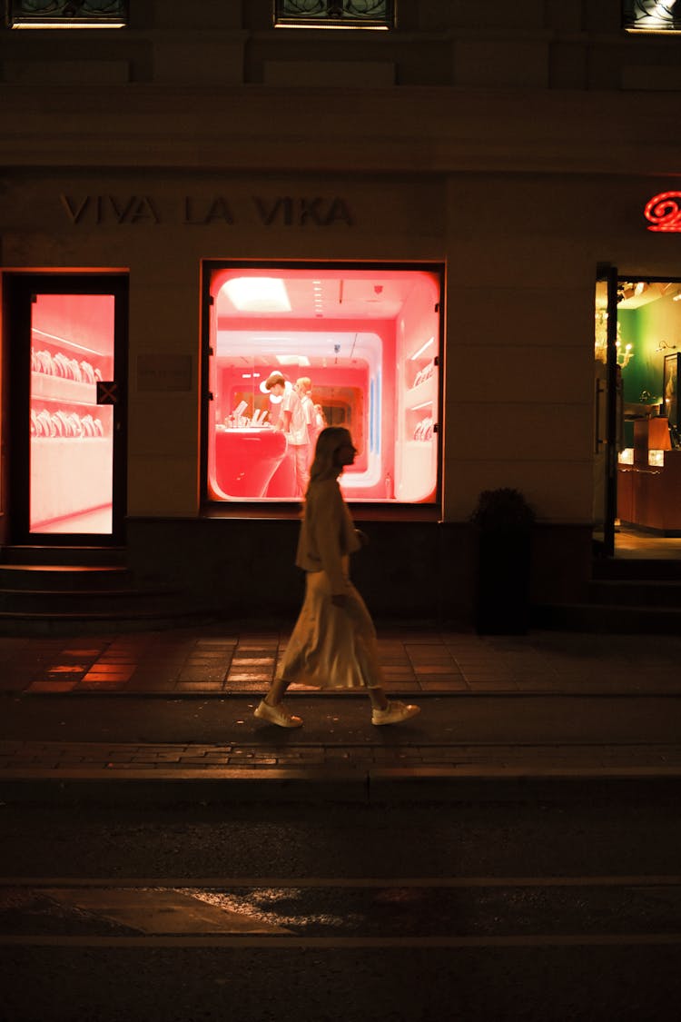 Woman Walking On A Street At Night