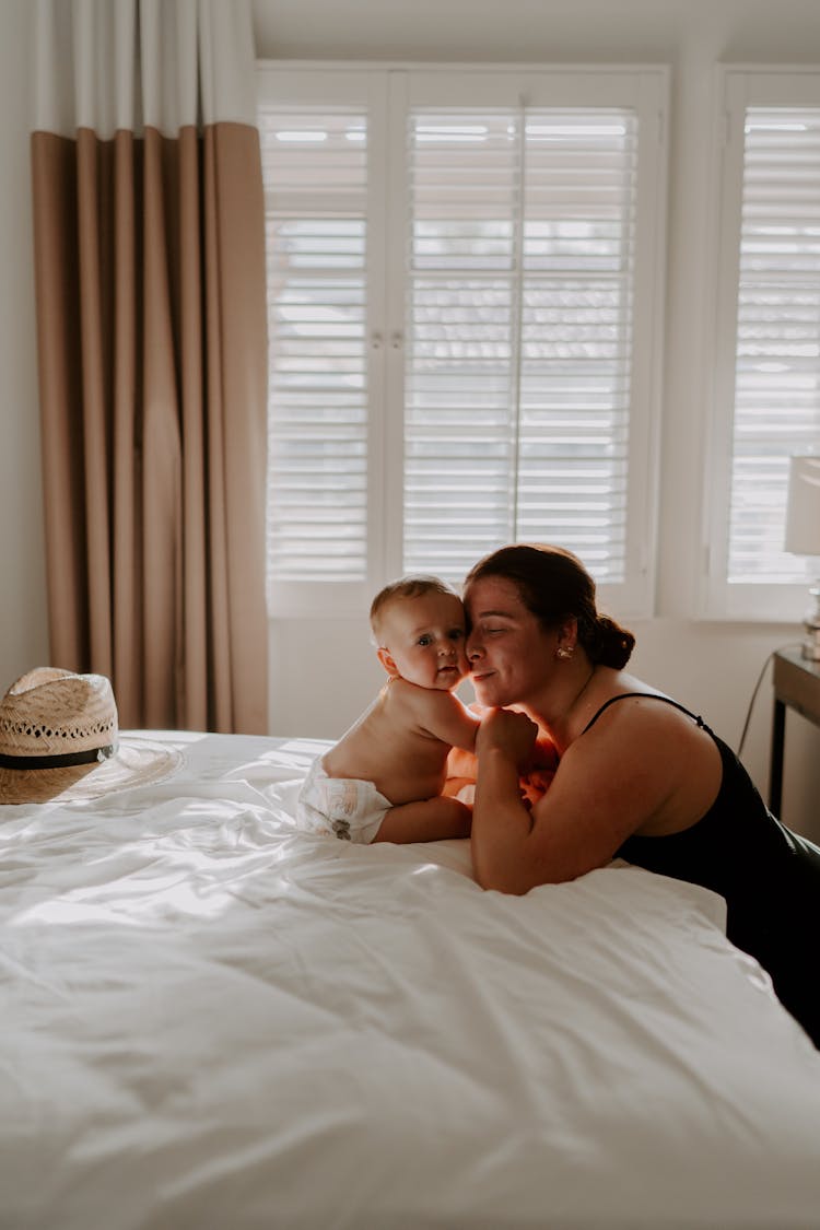 Woman With Her Baby In A Bed