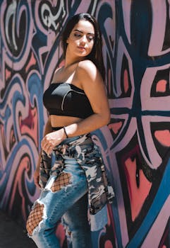 一位时尚女士身着都市服装，倚靠在充满活力的涂鸦墙边，展现出街头现代风格
