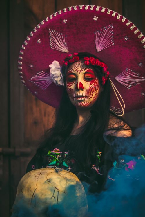 Free Vibrant portrait of a woman in traditional Day of the Dead attire with creative makeup and costume. Stock Photo