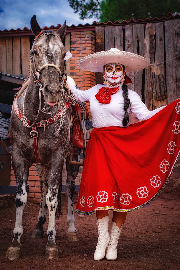 Woman In Traditional Mexican Costume And Face Paint Posing With A Horse