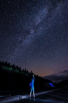 在晴朗的夜晚，一个人指着星空，可以看到银河