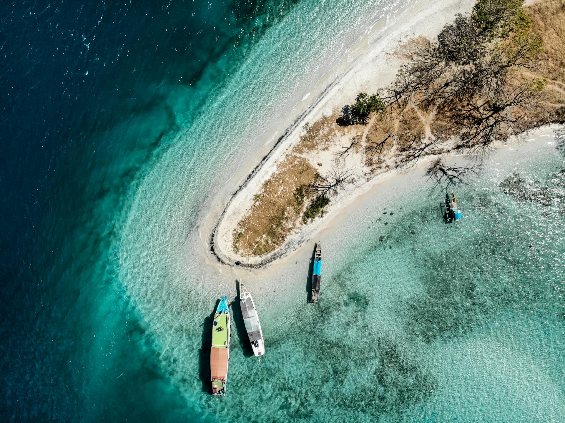 A stunning aerial view of Comoros island coastline with boats in turquoise waters.