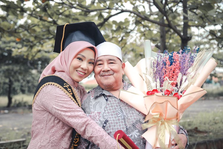 Smiling Daughter In Academic Hat Hugging Father