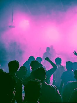 Vibrant nightlife scene with a crowd enjoying live music and bright stage lights.