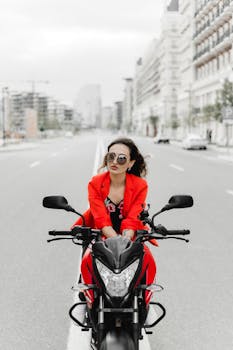 Stylish woman on a motorcycle in urban Baku street, embodying confidence.