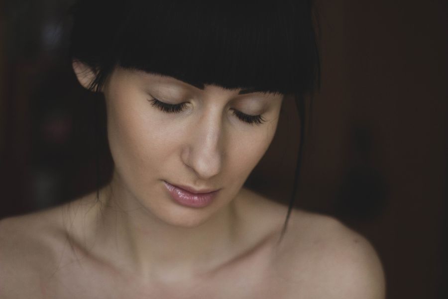 A woman with dark hair and a fringe looking down