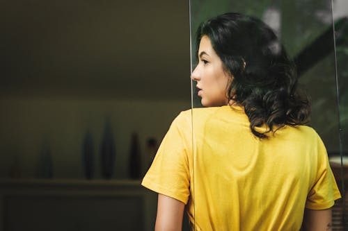 Mulher Vestindo Uma Camisa Apoiada Na Janela De Vidro