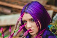 一位紫发女子的特写肖像，背景是鲜艳的花朵