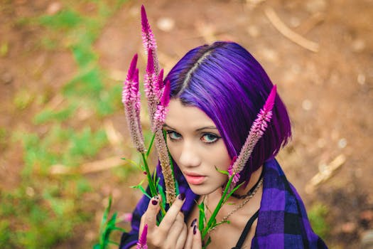 一位紫发女子与鲜艳花朵的户外特写肖像