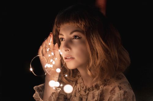 Free Captivating image of a woman holding glowing string lights, creating a dreamy atmosphere. Stock Photo