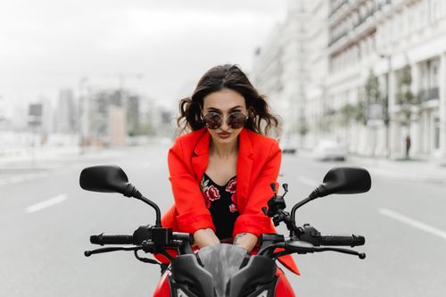 Free Stylish woman with sunglasses on motorcycle in urban Baku, Azerbaijan street. Stock Photo