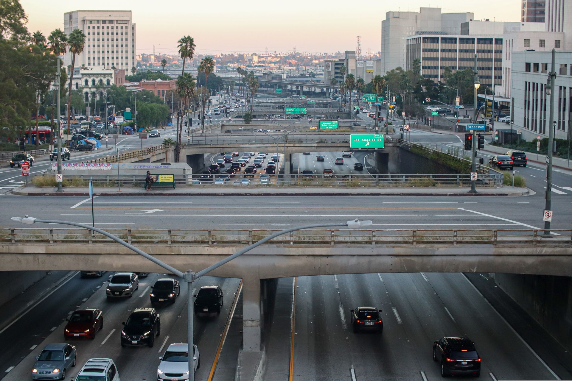 Captured during the day, showcasing the bustling highways and iconic buildings of Los Angeles.
