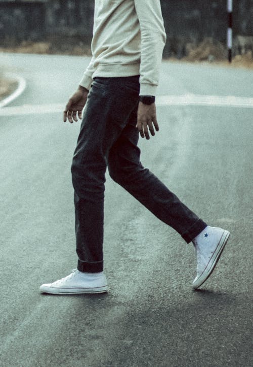 Free Man in Jeans and Sneakers Walking Down the Street Stock Photo