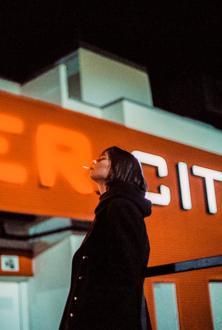 Woman With A Cigarette Standing Outside At Night 