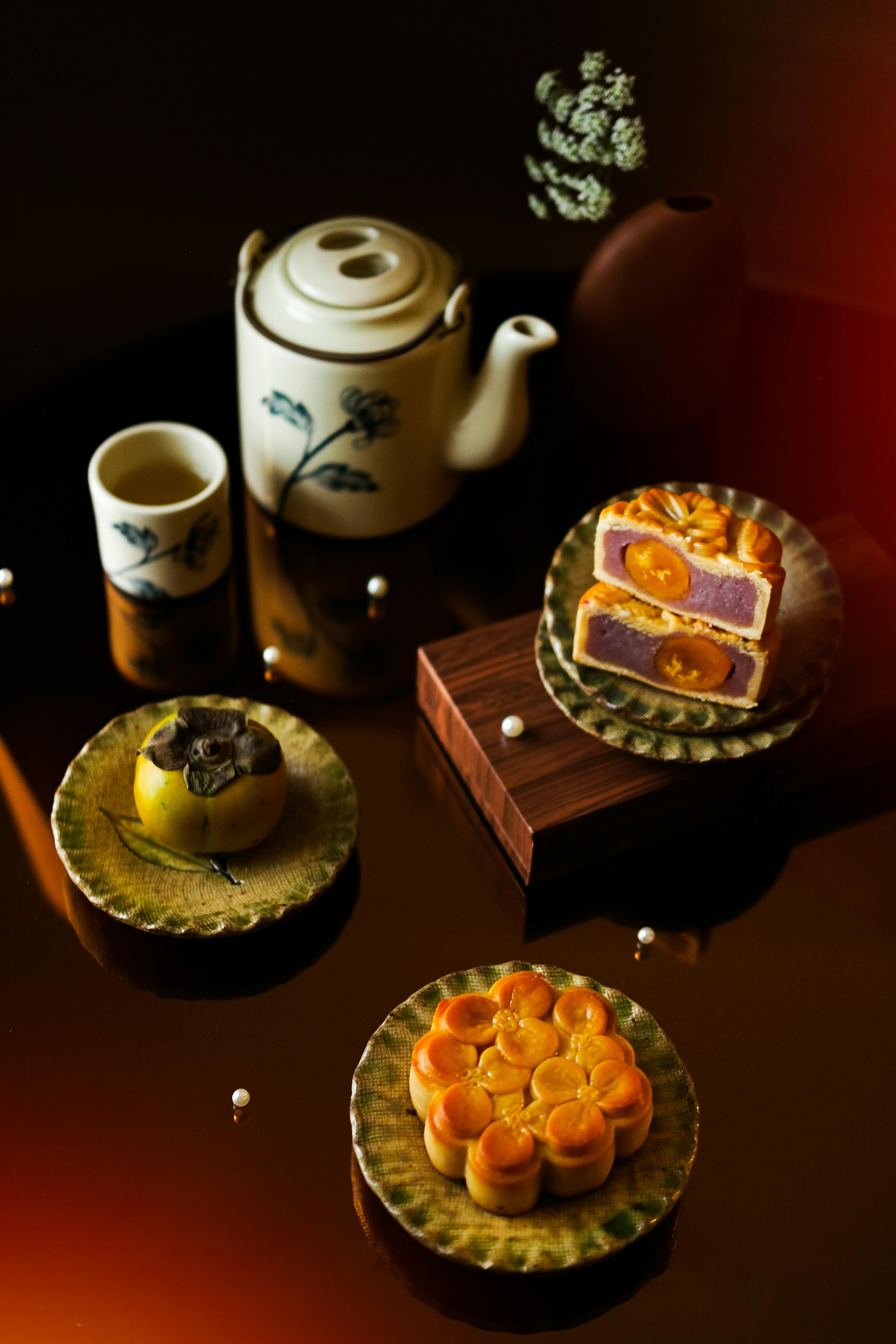 Traditional pottery teapot and mooncakes on display, capturing Vietnamese culture in artistic food photography.