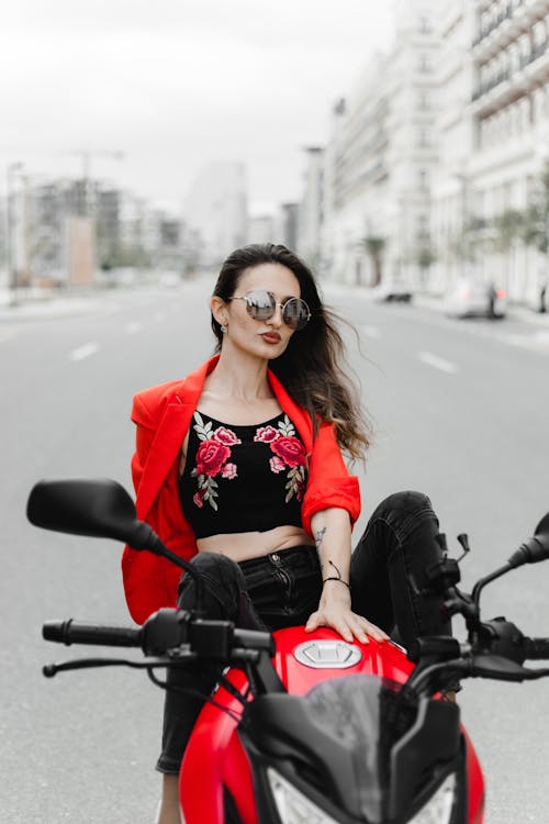 Woman in Sunglasses and Red Suit Jacket on Motorcycle