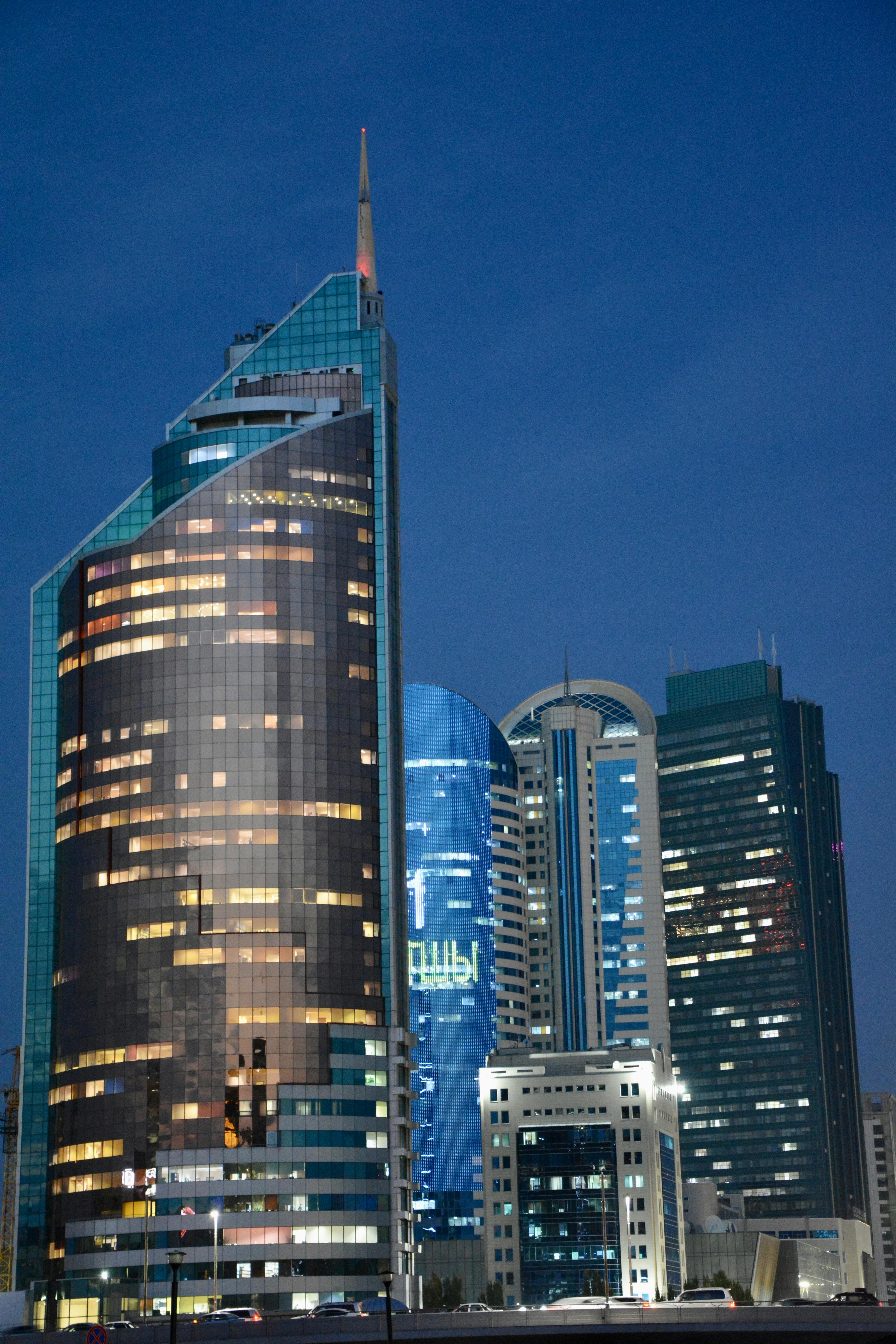 Night view of Astana's skyline showcasing illuminated modern skyscrapers against a clear sky.