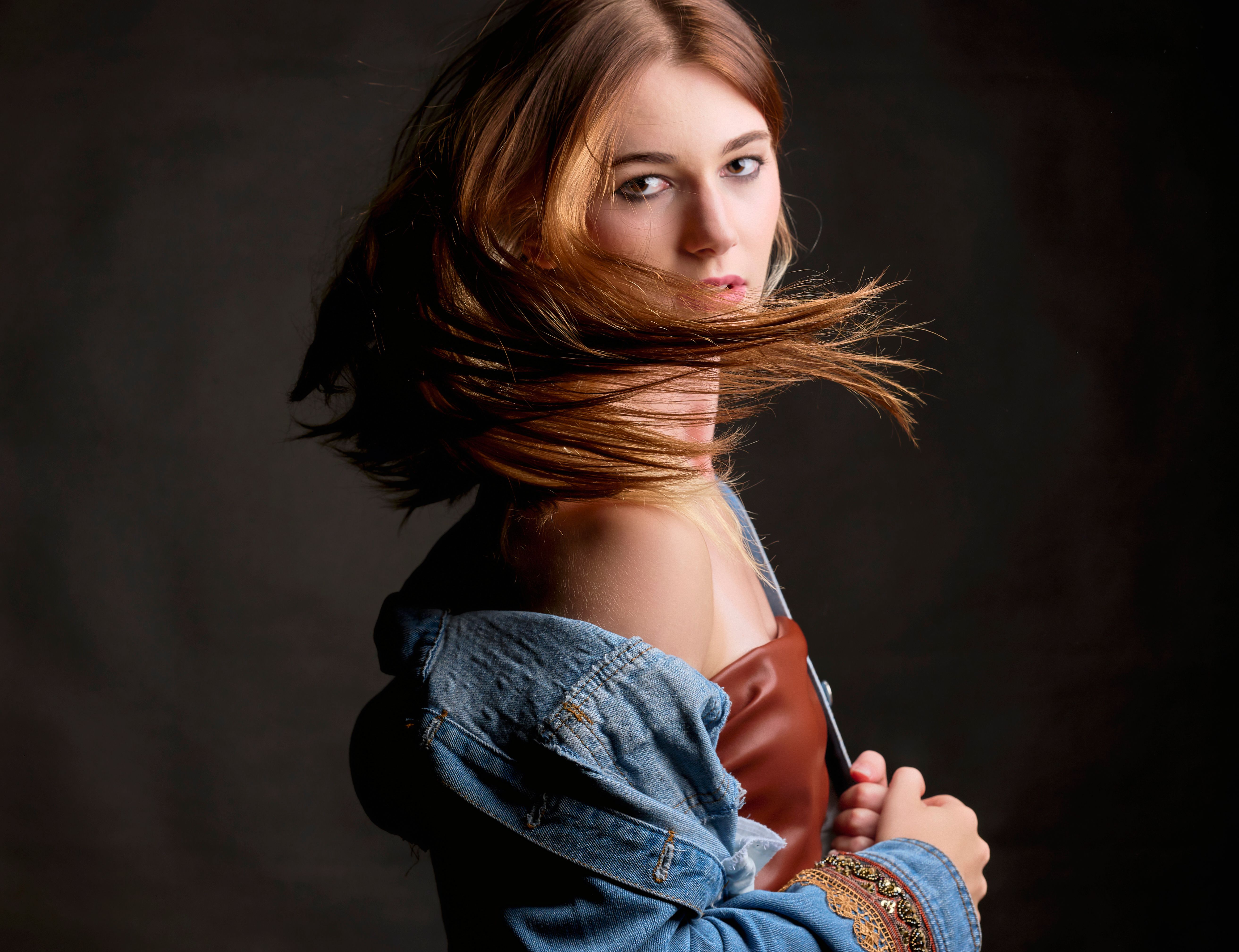 A Woman in Black Leather Jacket and Denim Pants Standing on the Road ...