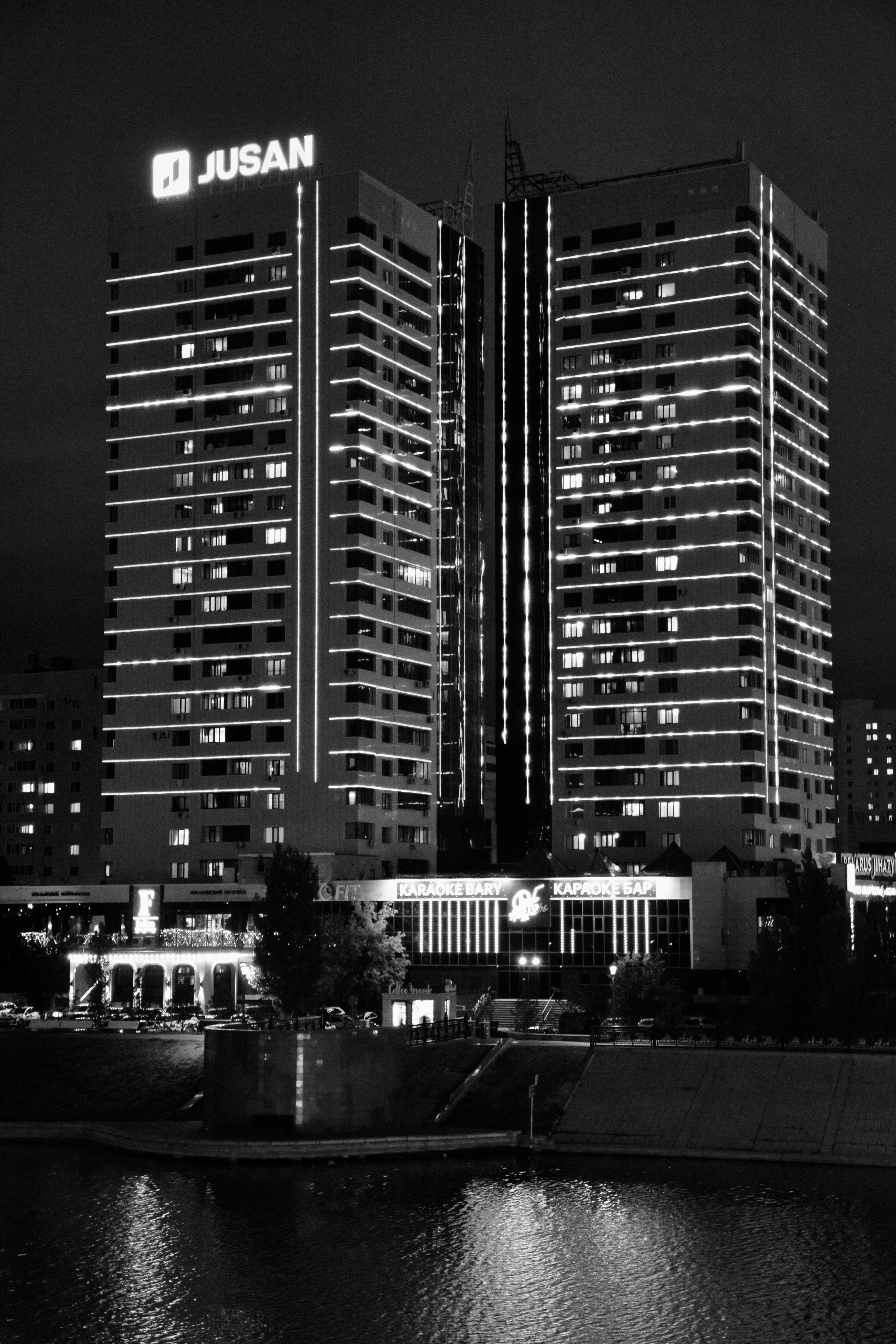 Black and white photo of illuminated high-rise building at night in Astana, Kazakhstan.