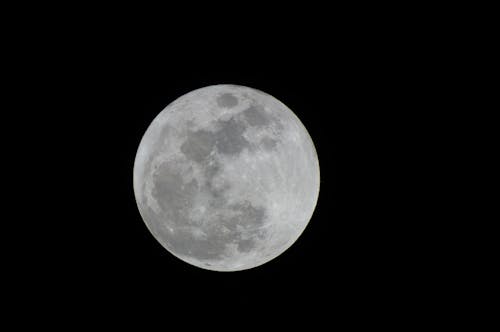 A full moon is seen in the night sky