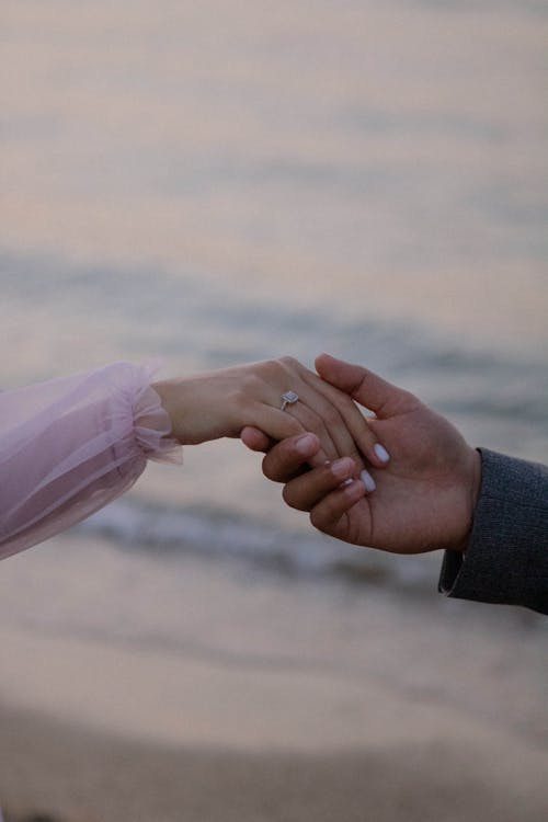 Man and Woman Holding Hands at a Sea Beach