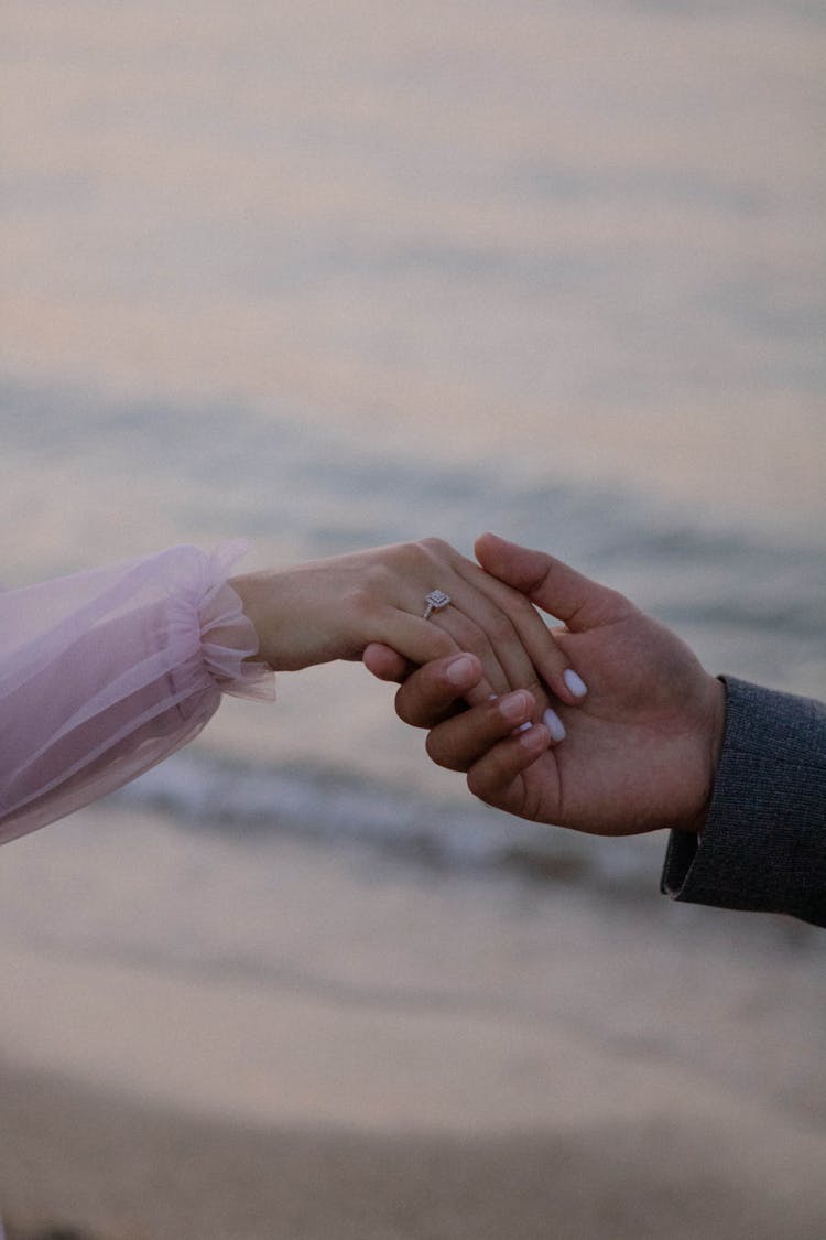 Man And Woman Holding Hands At A Sea Beach