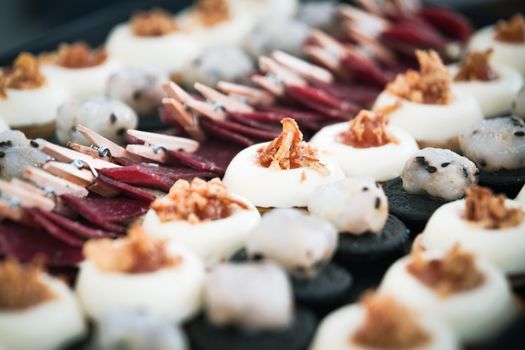Close-up of a gourmet appetizer platter featuring various pastries and toppings, perfect for culinary presentations.