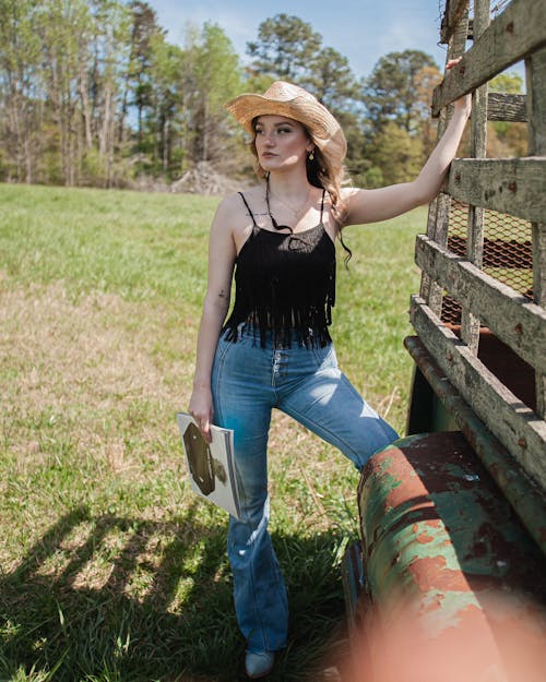 Young Woman Standing beside an Old Car in the Countryside