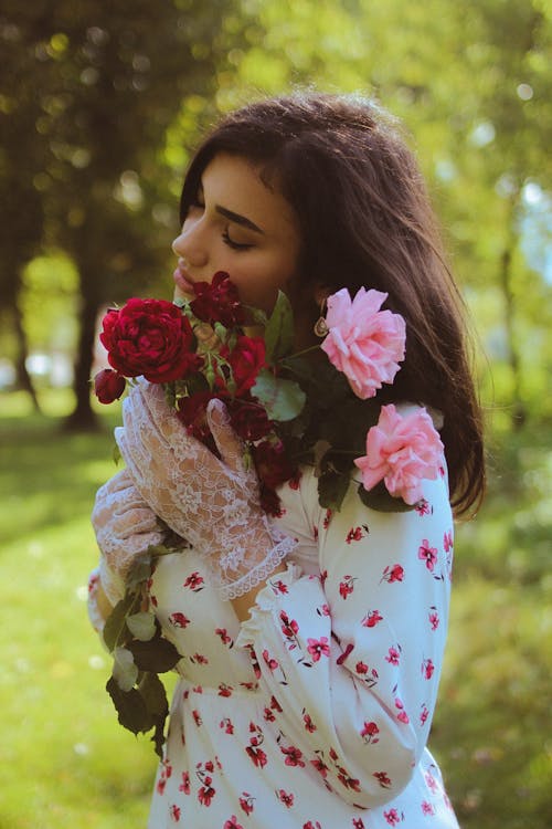 Portrait of a Long-Haired Brunette Holding a Bunch of Blooming Roses